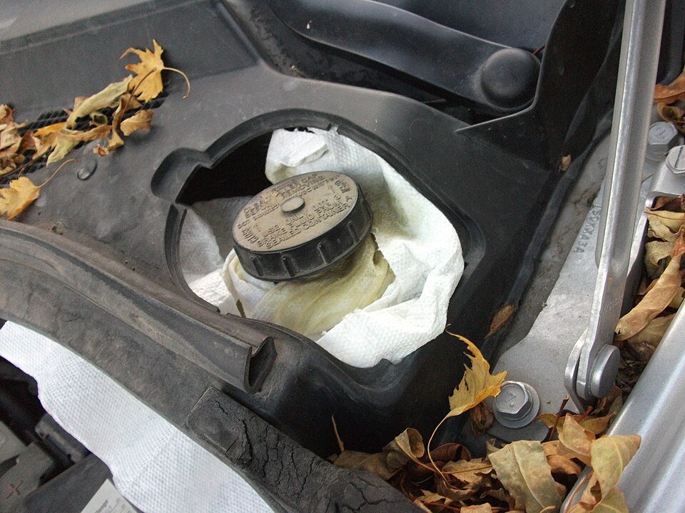Brake fluid reservoir with a labeled cap in an engine compartment